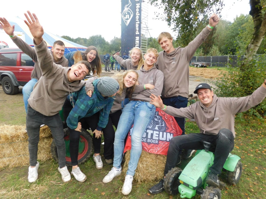 Deelnemers verzamelen zich bij de strobalen op het terrein.