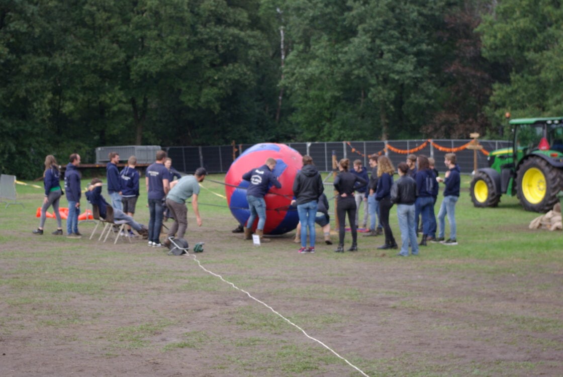 Een groep speelt samen een actief spel op het veld.
