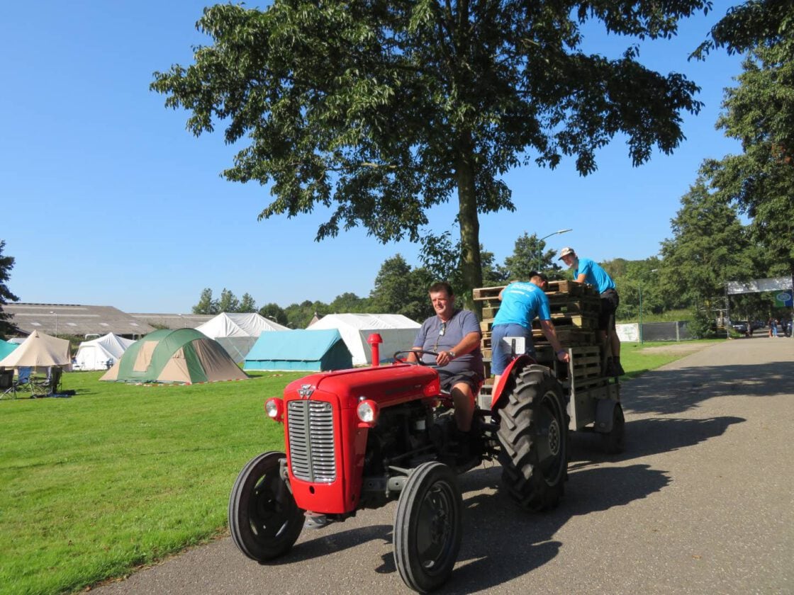 Een rode tractor rijdt over het terrein tijdens de Kaderschouw.