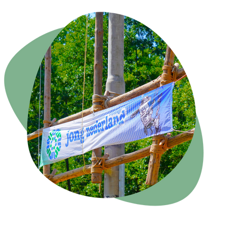 Spandoek van Jong Nederland gespannen tussen houten palen van een klimrek in het bos